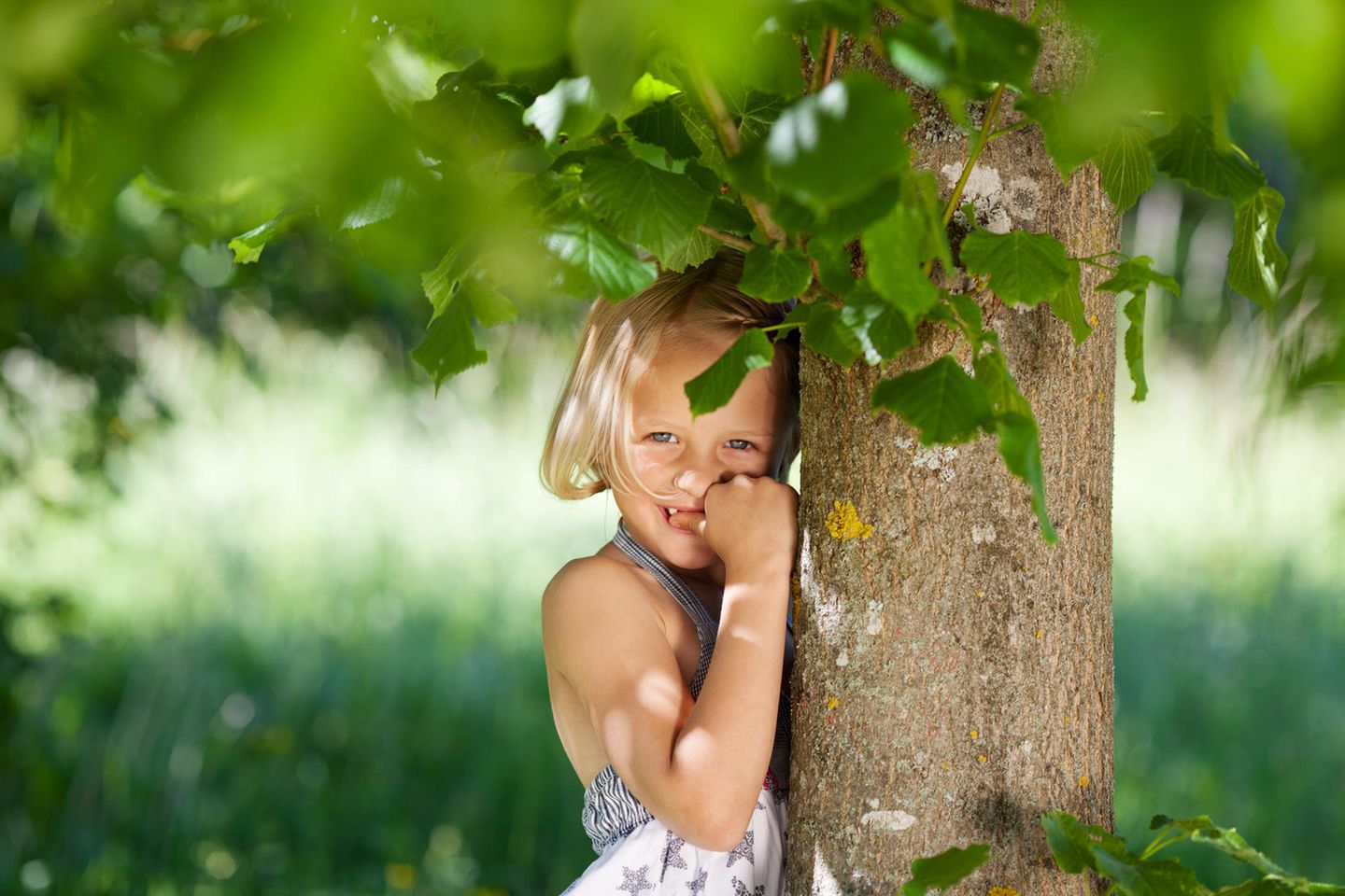 Introvertiertes Kind? Schüchternes Mädchen steht unter einem Baum