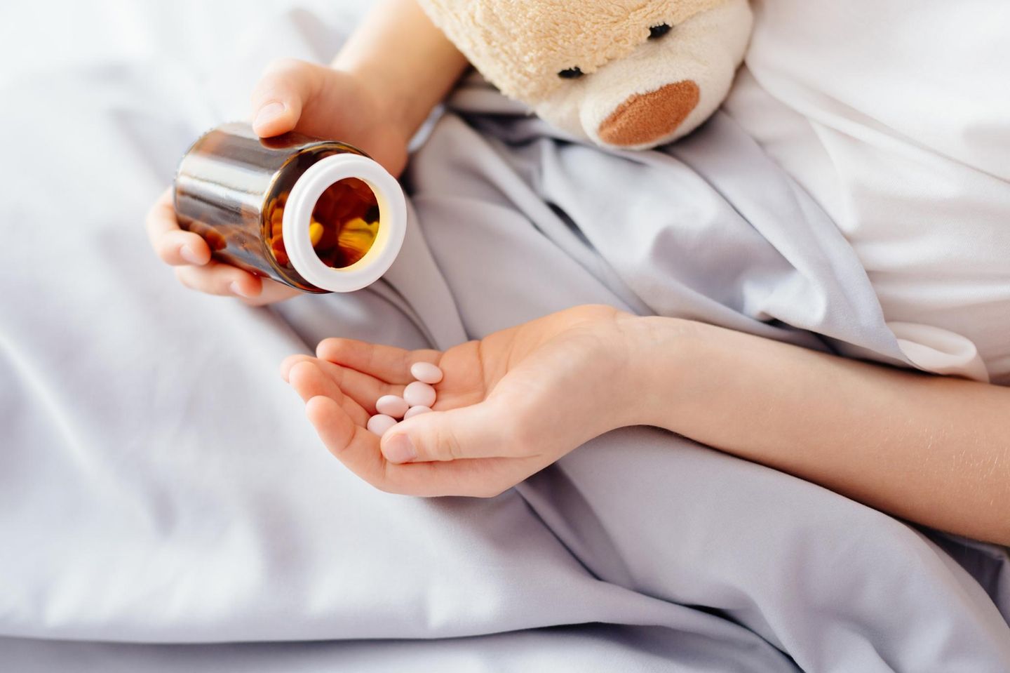 Antibiotika: Tabletten in einer Kinderhand