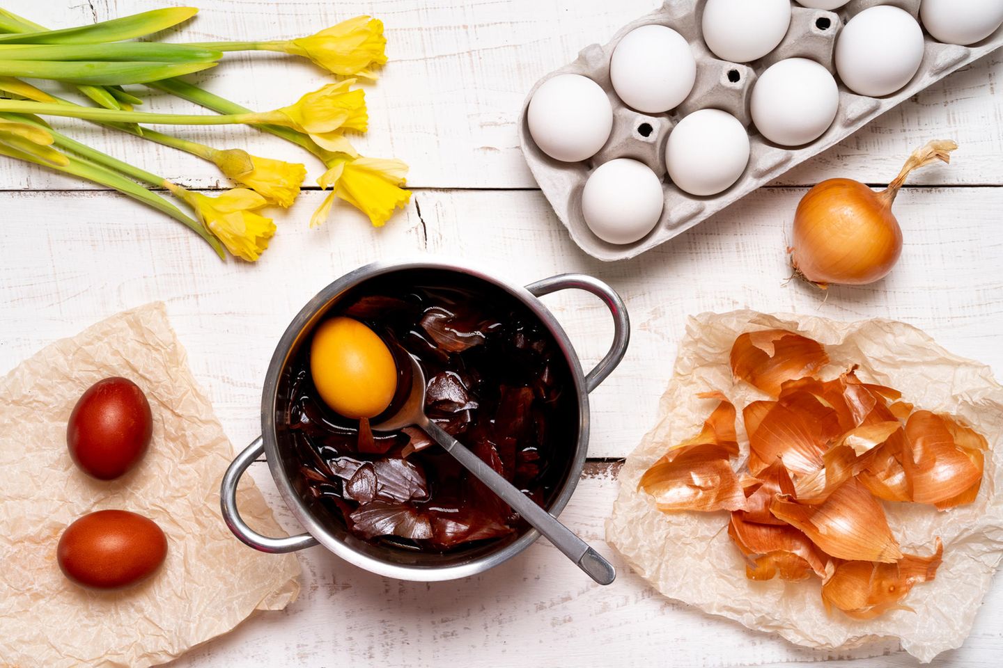 Eier färben mit Zwiebelschalen: Ein Topf mit Zwiebelschalen und einem Ei