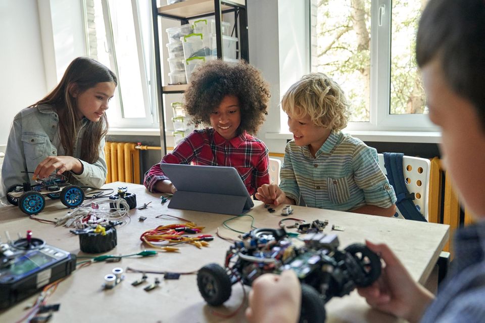 Programmieren für Kinder: Kinder programmieren einen Roboter in der Schule