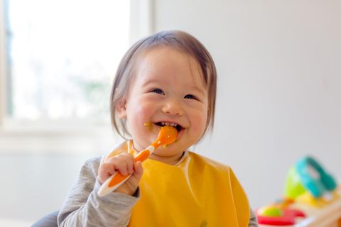 Babynahrungszubereiter im Test: Glückliches Kleinkind isst Babybrei.
