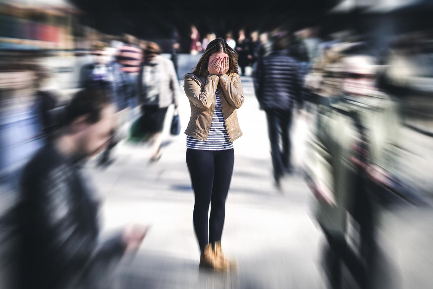 Single gleich sorgenfrei? Eine Frau steht auf der Straße und hält sich die Hände vor das Gesicht