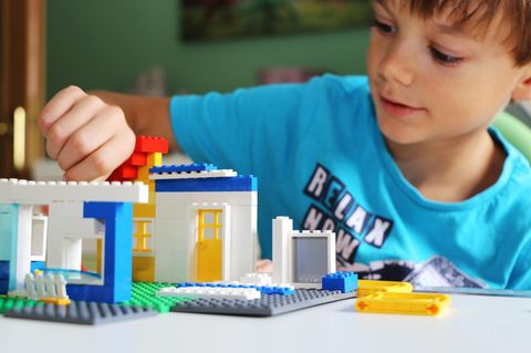 Lego Alternativen: Junge spielt mit Klemmbausteinen einer Lego Alternative