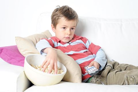 Kind mit Popcorn vorm Fernseher