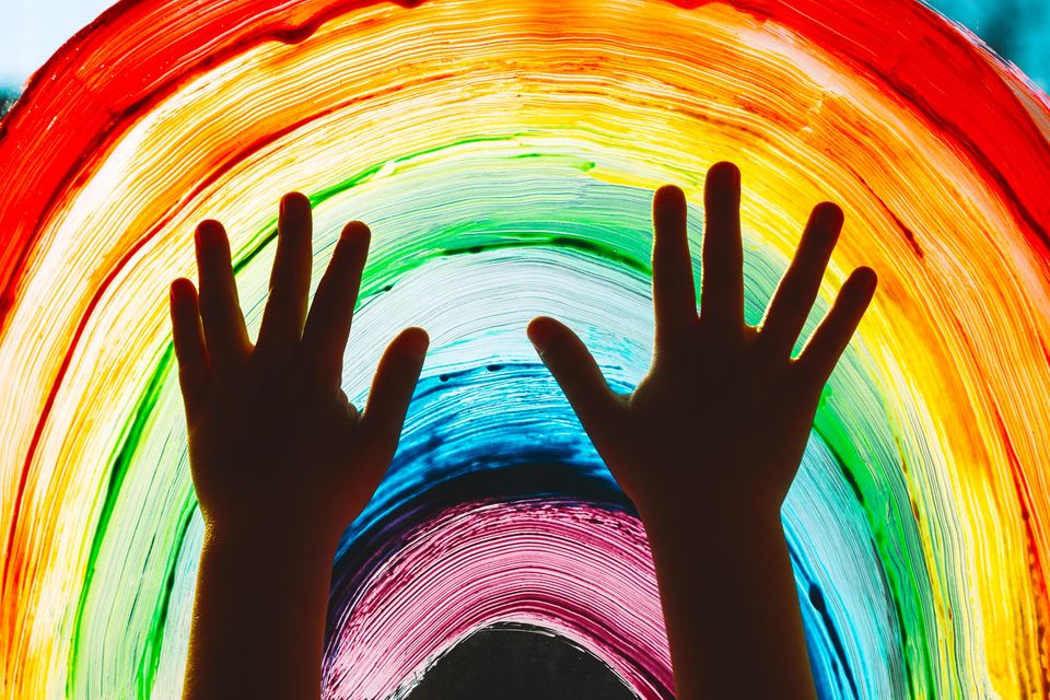 Kinderhänder vor einem Regenbogen