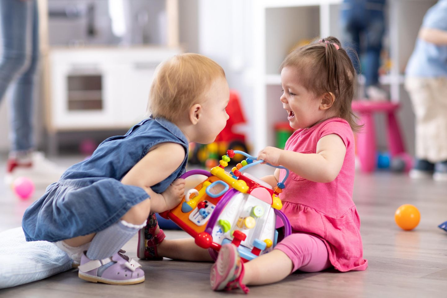 Miteinander vertragen: zwei Kleinkinder streiten um ein Spielzeug