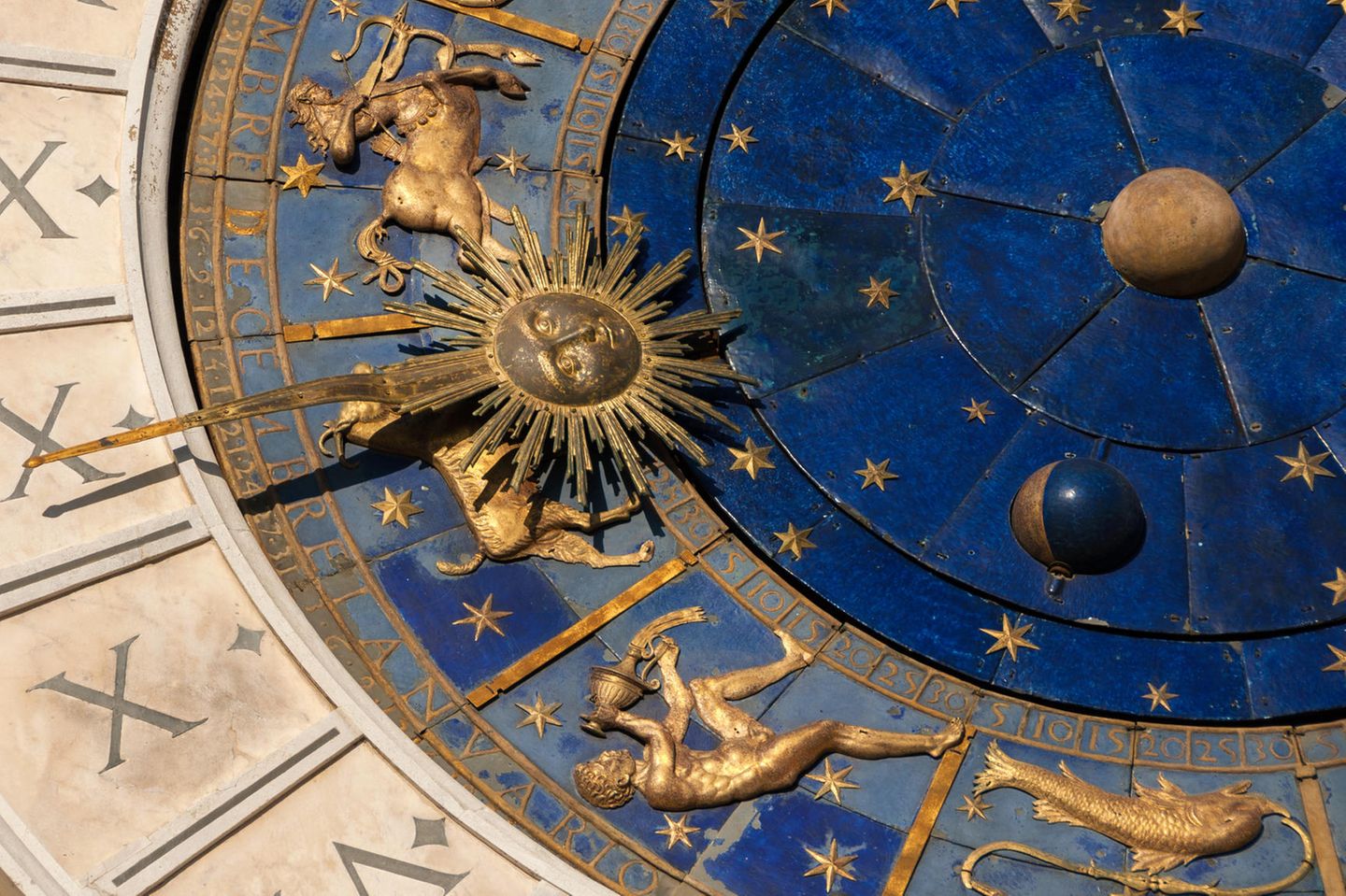 Aszendent Wassermann: Goldenes Symbol des Sternzeichen Wassermann an einer antiken Uhr