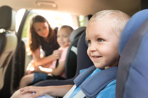 Kindersitz-Test: Kleines Kind wird im Kindersitz angeschnallt.