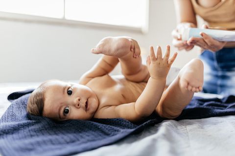 Windel-Quiz: Frau wechselt die Windeln eines Babys.