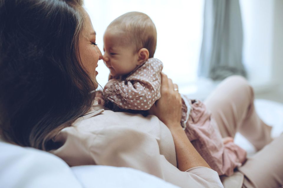 Frau kuschelt mit Baby