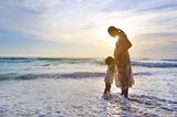 Andere Länder, andere Sitten: Schwangere Mutter mit Tochter am Strand