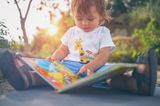 Meilensteine im ersten Lebensjahr: Baby schaut in ein Buch