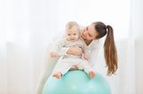Schaukel mich! Mütter hält ihr Baby auf einem Gymnastikball
