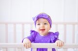Babys lieben starke Farben: Baby in lila Kleidung