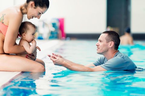 Babyschwimmen: Baby mit seinen Eltern am Beckenrand