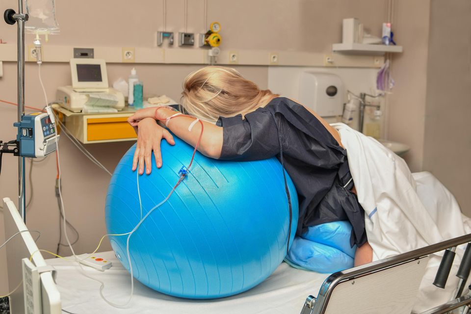 PDA bei der Geburt: Frau in den Wehen liegt auf einem Gymnastikball