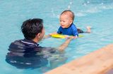 Sportlich aktiv, Baby dabei: Vater schwimmt mit Baby