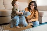 Bewegungsspiele mit Kindern: Baby auf einem Schaukelpferd
