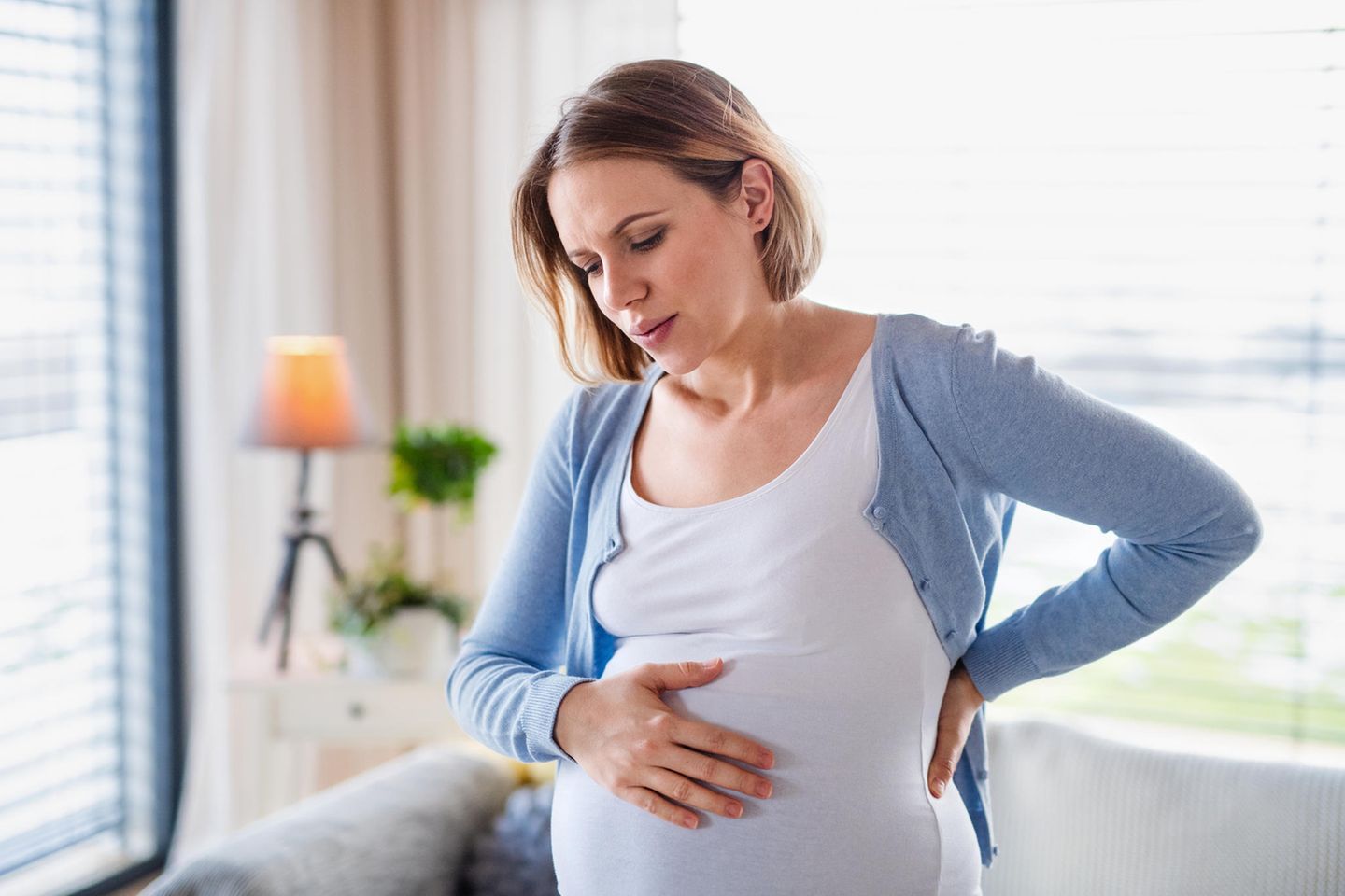 Übungswehen: Schwangere Frau fasst sich an den Bauch