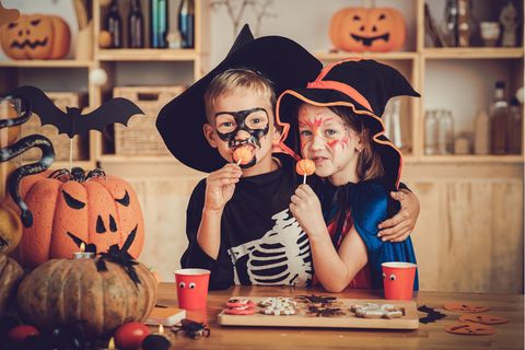 Halloweenparty für Kinder: Junge und Mädchen feiern verkleidet Halloween