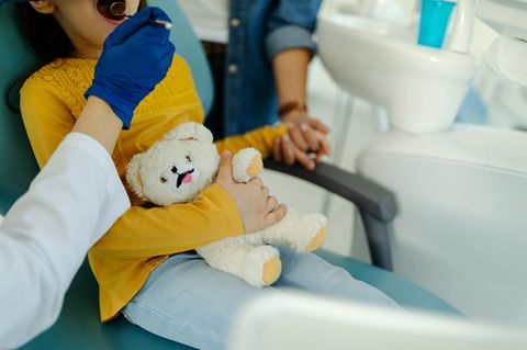 Angst vorm Zahnarzt: Ein Kind sitzt mit Teddybär beim Zahnarzt