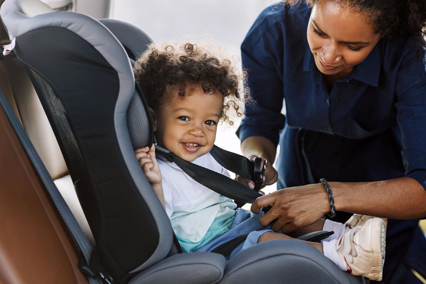 Entspannte Autofahrten mit Baby: Mutter schnallt ihr Kind im Autositz an
