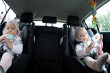Entspannte Autofahrten mit Baby: Kind mit Schnuller und Spielzeug im Kindersitz