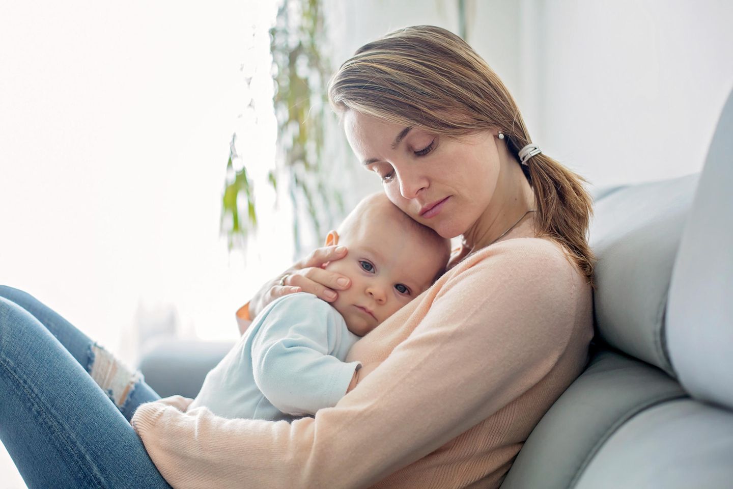 Ätherische Öle für Babys: Frau kuschelt mit Baby auf dem Sofa