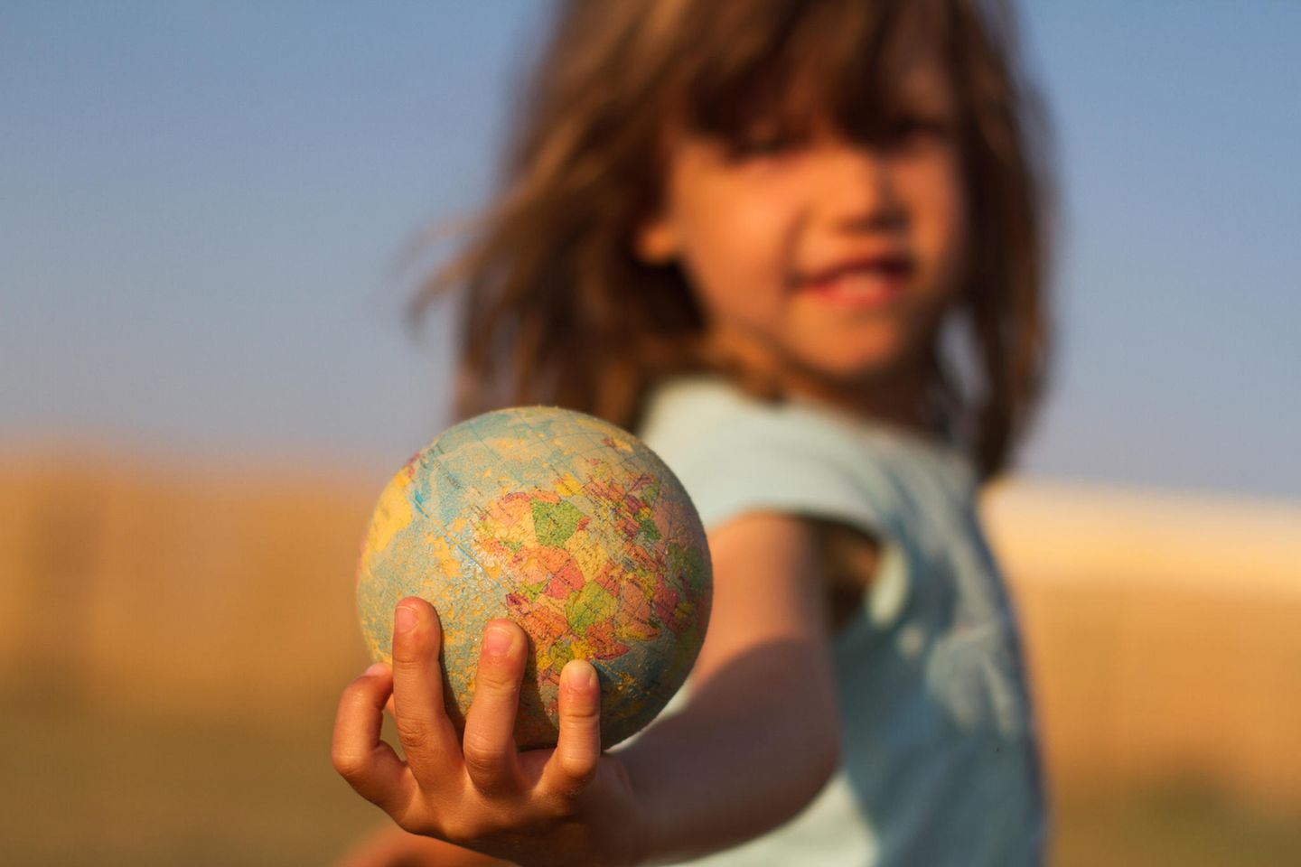 Weltkindertag 2022: Ein Kind hält einen kleinen Globus in die Kamera