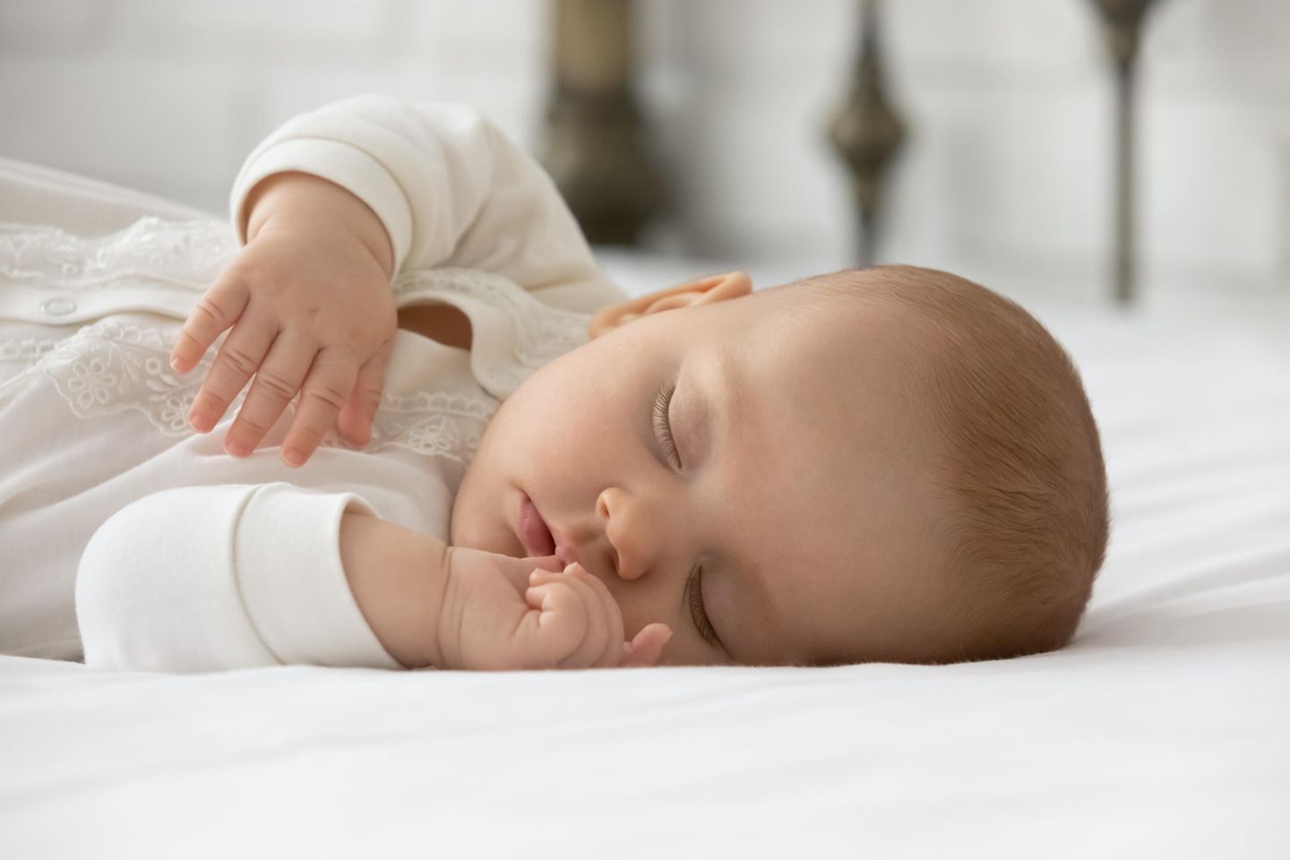 Welche Matratze für Kinder: Baby schläft auf fester, weißer Matratze
