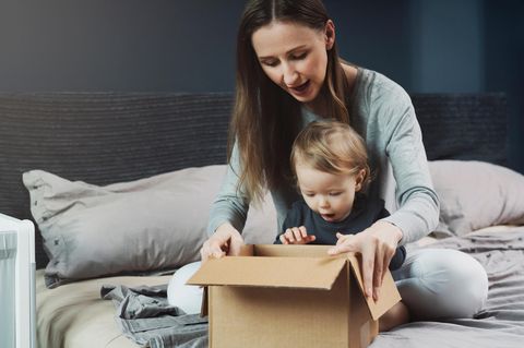 Leichter leben: eine Mutter sitzt mit ihrem kleinen Kind vor einem Pappkarton