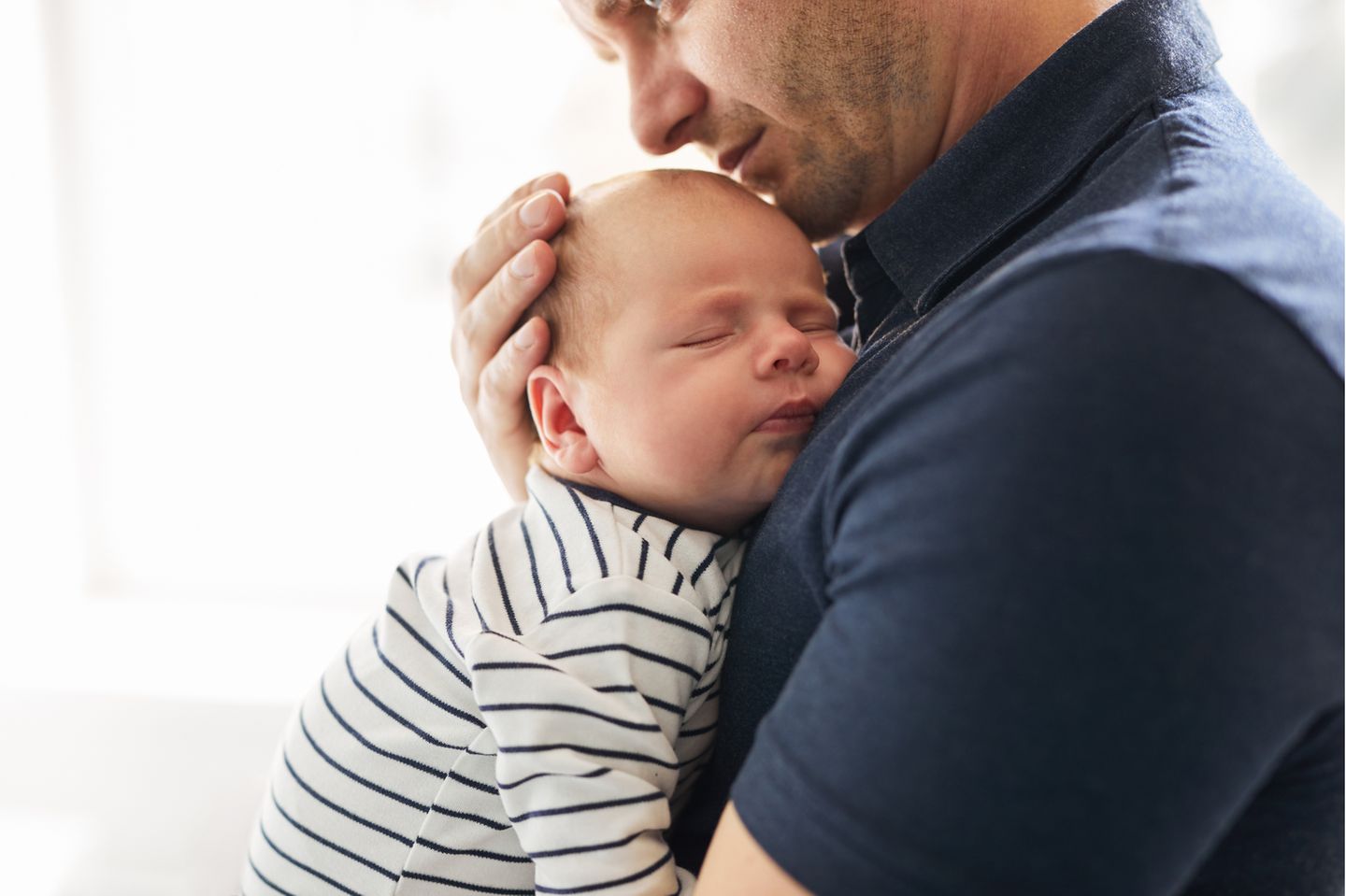 Ich gebäre: Vater hält Neugeborenes im Arm