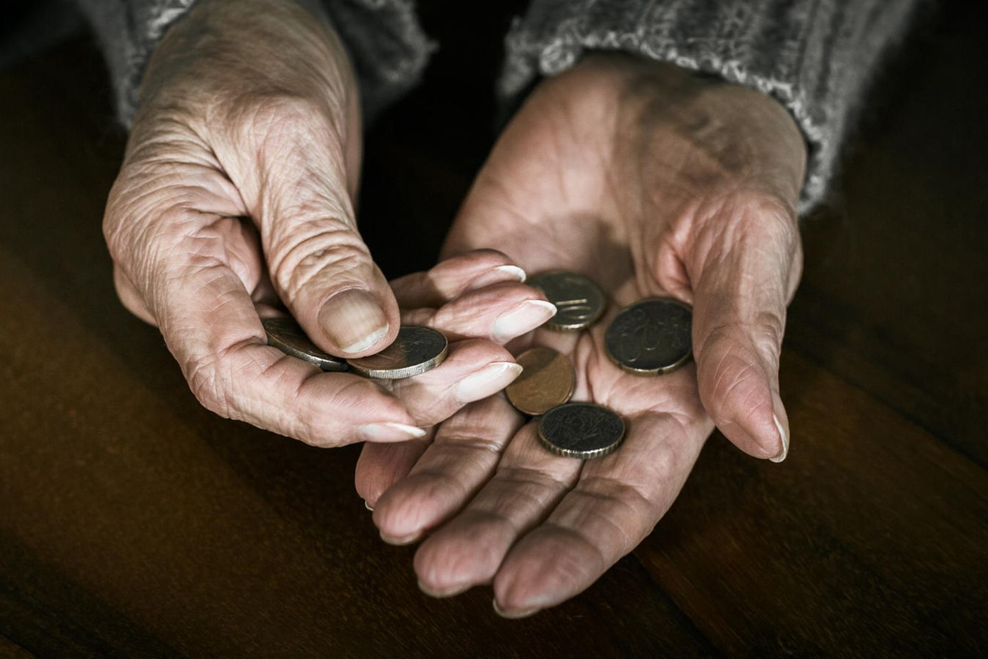 Spar-Tipps von Oma: Kleingeld in den Händen einer alten Person