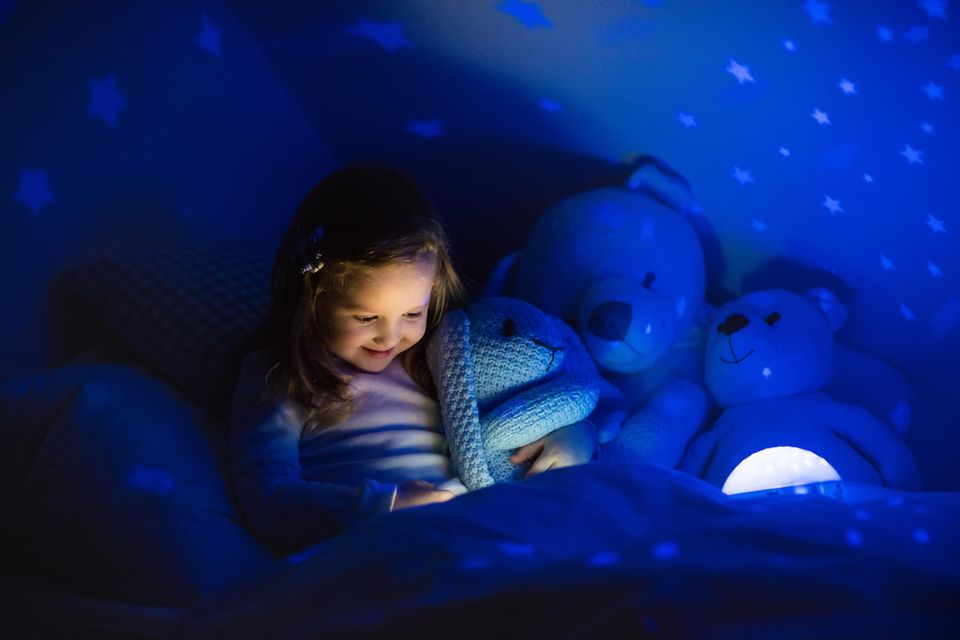 Sternenhimmel-Projektor-Test: Ein Mädchen liest ein Buch unter dem Licht eines Sternenhimmel-Projektors.