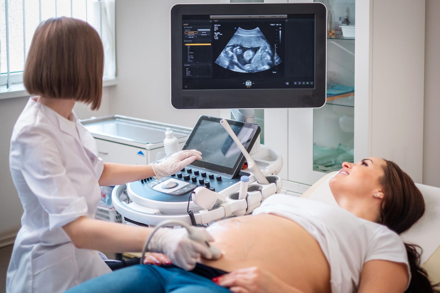 Schwangere wird von Ärztin mit Ultraschall untersucht