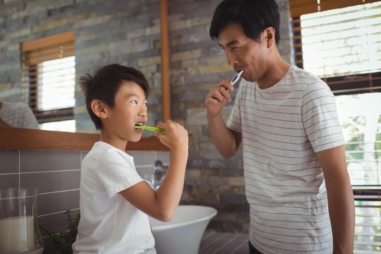 Ein Vater und sein Sohn putzen sich die Zähne