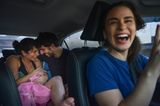 Geburt im Auto: Eltern mit Geburtshelferin und Baby im Fahrzeug