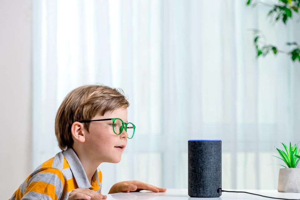 Sind Alexa, Siri & Co. schlecht für Kinder? Kind spricht in einen Sprachassistenten