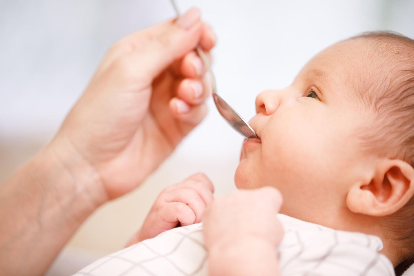 Vitamin D für Babys: Baby trinkt von einem Löffel