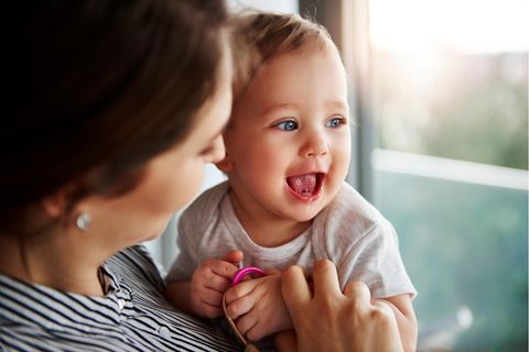 Babynamen aus den 70ern: Baby Mädchen auf dem Arm ihrer Mutter