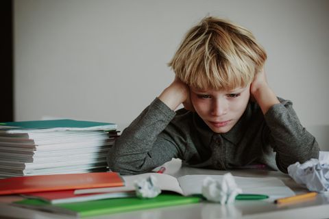 Tipps bei lernfaulen Teenies: Junge sitzt frustriert an den Hausaufgaben