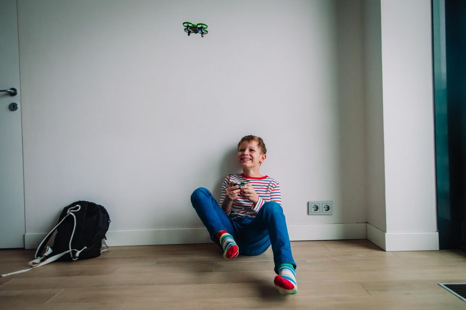 Drohnen für Kinder im Vergleich: Junge spielt mit Drohne in der Wohnung
