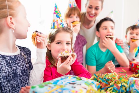 Kinder feiern einen Kindergeburtstag und essen Muffins