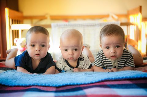Babyhaare: Drei Babys mit unterschiedlichen Haaren schauen uns, auf dem Bauch liegend, an