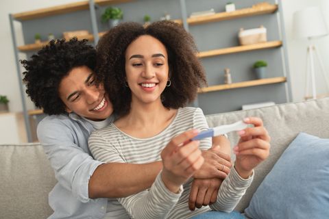 Pärchen lacht und schaut auf einen Test