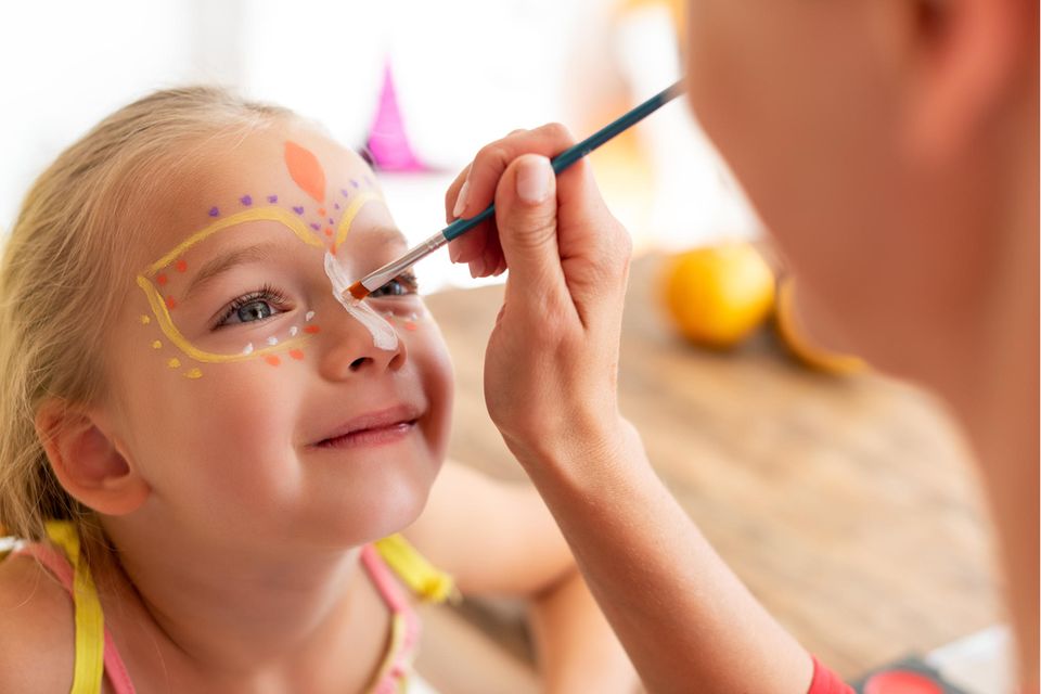 Kinderschminke-Test: Lachendes Mädchen als Schmetterling geschminkt.