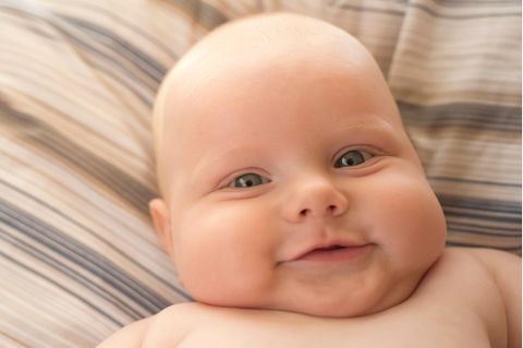 Ein Baby mit Pausbacken lächelt in die Kamera