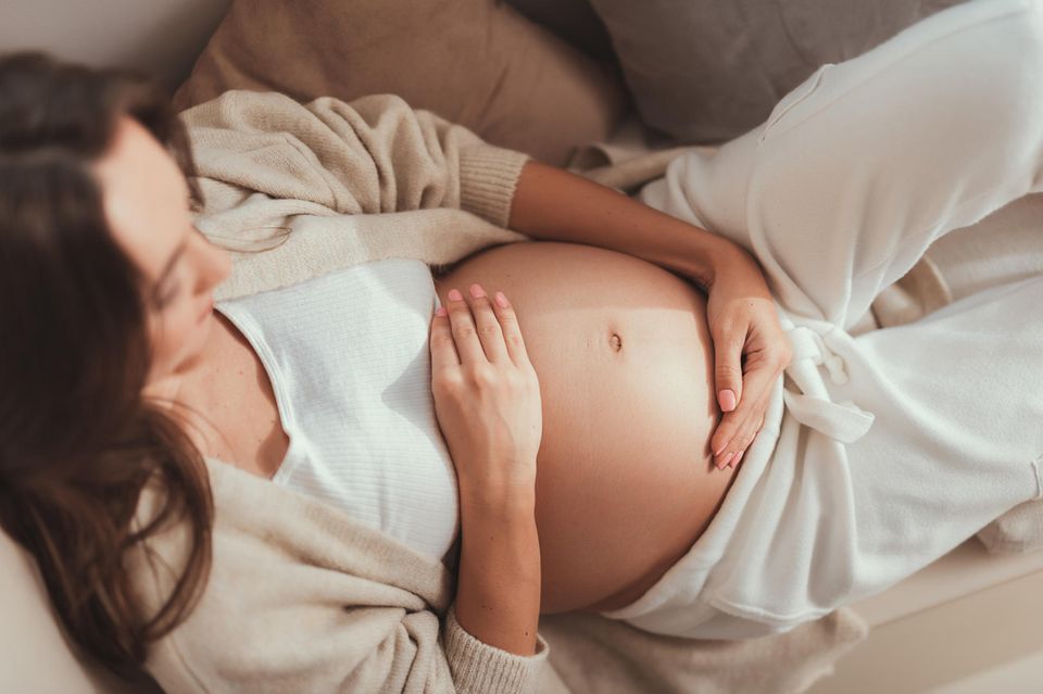 schwangere Frau hält ihren Bauch