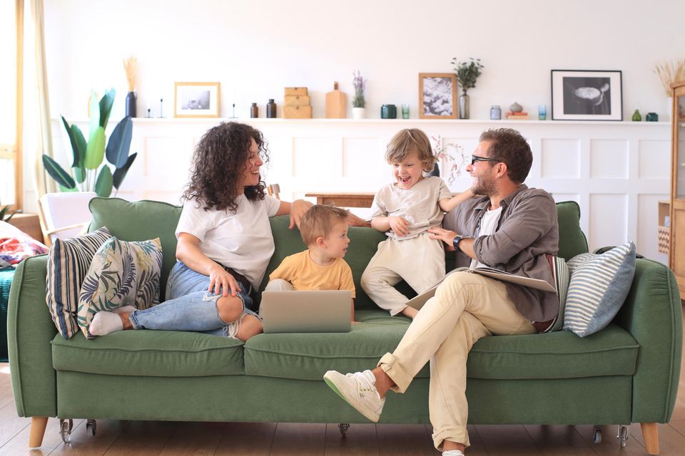 Witzige Situationen im Alltag: Familie mit Kindern lachen gemeinsam im Wohnzimmer