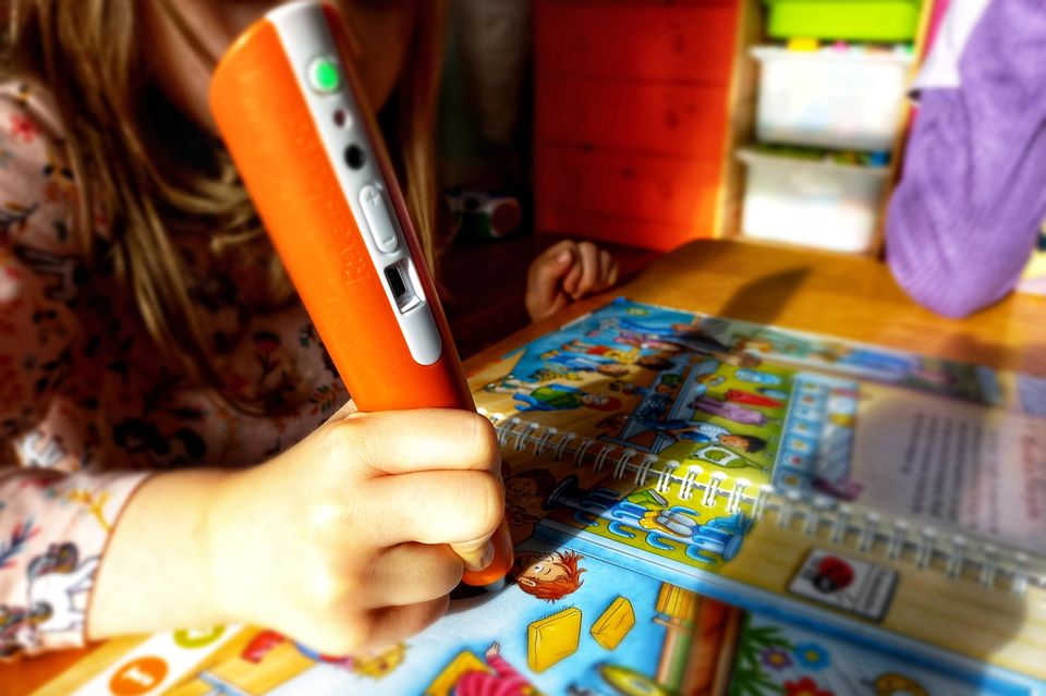 Tiptoi Starter-Set im Test: Kind tippt mit Tiptoi Stift auf ein Bilderbuch.